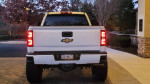 Back view of a lifted 2019 Chevrolet Silverado 1500 with customized features and off-road tires.