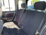 Interior view of a 2010 Nissan Cube SL showcasing spacious back seats and fabric upholstery.
