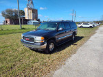 2006 GMC Yukon XL K1500 4x4 parked on a grassy area, showcasing its exterior and body condition.
