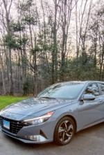 2021 Hyundai Elantra Limited in Electric Shadow color parked in nature, showcasing sleek design and pristine condition.