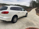 2013 Buick Enclave in white color parked on a driveway, showcasing its sleek design and alloy wheels.