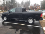 2015 Ram 1500 pickup truck in black, parked, showcasing side view and details.