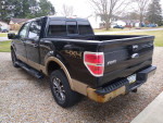 2011 Ford F-150 4x4 SuperCrew in fair condition with visible rust, parked in a residential area.