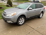 2011 Subaru Outback 2.5i Premium AWD parked on a driveway, showcasing its sleek design and features.