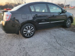 2011 Nissan Sentra sedan in black, featuring alloy wheels and 140,000 miles, parked on pavement.