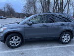 Side view of a gray 2010 Honda CR-V EX-L parked, showcasing its exterior features and design.