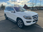 2014 Mercedes-Benz GL450 4MATIC in white, showcasing sleek design parked in a lot with clear skies.