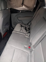 Interior view of a 2013 Kia Sorento showing rear seats with some wear and debris, ideal for mechanics.