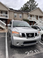 2011 Nissan Armada Platinum Edition parked in a driveway, showcasing its spacious design and exterior features.
