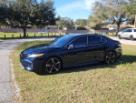 2020 Toyota Camry XSE FWD parked in a grassy area with a panoramic roof and Galactic Aqua paint.