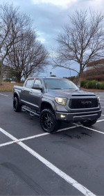 2014 Toyota Tundra Platinum 4WD in gray with 20" wheels and off-road tires parked