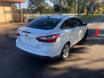 2014 white Ford Focus parked, showing slight damage and mileage of 63,000 miles.