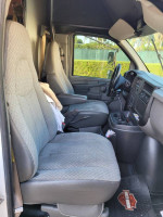 Interior of 2004 Chevy 3500 Cut Away box truck showing two spacious front seats and dashboard.