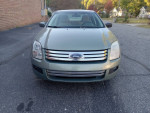 2009 Ford Fusion in green with 100,000 miles, ideal for work or rideshare, featuring a dent but overall in good condition.