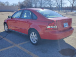 2007 Volvo S40 2.4i sedan in red, showcasing a clean design and manual transmission, parked outdoors.