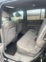Interior view of a 2014 Honda Pilot EX-L showing spacious back seats with leather upholstery.