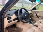 Interior view of a 2007 BMW X3, showcasing luxurious leather upholstery and dashboard details.