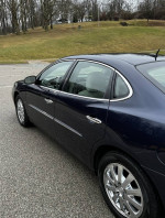 Side view of 2008 Buick LaCrosse CX in Imperial Blue with shiny chrome wheels and a clean interior.