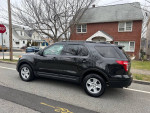 2014 Ford Explorer XLT FWD in black, parked on a residential street with a clear view of the side profile.