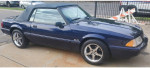 1993 Ford Mustang LX convertible in royal blue with chrome rims parked on pavement.
