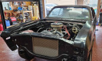 1972 Chevrolet Nova engine bay with rebuilt parts in a garage setting