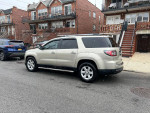 2013 GMC Acadia SLE with third-row seating parked on the street, showcasing its all-wheel drive and clean exterior.