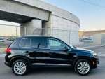 2012 Volkswagen Tiguan SE 4Motion AWD with leather seats and alloy wheels parked in an urban setting.