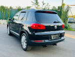2012 Volkswagen Tiguan SE 4Motion AWD parked on a road, showcasing clean design and alloy wheels.