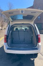 Rear view of a 2009 Dodge Grand Caravan with an open hatch, showcasing a spacious interior suitable for wheelchair accessibility.
