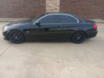 2011 BMW 328I convertible with 96,000 miles, sleek black exterior and aftermarket wheels parked on concrete.