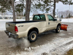 2000 Ford F250 Super Duty plow truck with a Western Unimount plow, parked in snowy conditions.