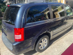 2009 Chrysler Town & Country minivan parked in a driveway, showcasing its clean exterior and rear design.