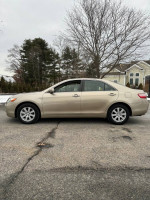 2007 Toyota Camry XLE FWD in gold color parked on a street, showcasing its sleek design and pristine condition.