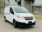 White 2015 Chevrolet City Express LS Mini-Cargo Van parked in urban setting, showcasing its clean exterior and practical design.