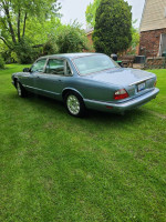 2003 Jaguar XJ8 in Zircon Blue parked on grass, featuring clean exterior and luxury design.