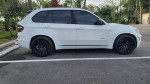 2010 BMW X5 SUV in white with new Vossen 22-inch wheels parked in a lot.