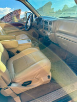 Interior view of a 2001 Ford F350 dually Lariat with beige leather seats and dashboard