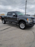 2017 Ford F250 Platinum truck in gray with a clean title and 98k miles, parked on a concrete surface.