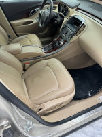 Interior view of a 2011 Buick LaCrosse showcasing immaculate beige leather seats and dashboard.