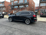 2016 BMW X5 parked on a street, showcasing its sleek design and all-wheel drive features.