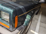 Close-up view of the 2001 Jeep Cherokee Sport showcasing the front fender and headlights.