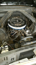 Engine bay of a 1964 Ford Falcon Convertible with chrome upgrades and original features.