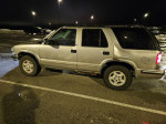 1999 Chevrolet Blazer parked at night, showcasing its unique design and low mileage of 63,000 miles.