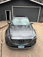 2019 Mazda CX-9 Grand Touring in gray parked in front of a house with a sunroof and roof rack.