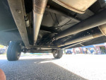 Undercarriage view of a 1973 Ford F-100, showcasing the rebuilt motor and transmission components.