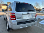 Rear view of a 2012 Ford Escape XLT FWD, silver color, clean with no rust, parked in a residential area.