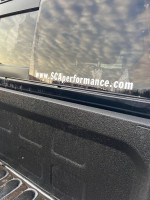 Close-up of a Ram 2500 truck with a Black Widow package, featuring running boards and a spray-in bed liner.