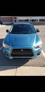 Front view of a 2013 Mitsubishi Outlander Sport AWD in blue, showcasing its sleek design and clean condition.