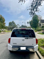 Rear view of a well-maintained Nissan Armada parked on a residential street under clear skies.