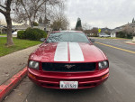 2005 Ford Mustang Deluxe Coupe RWD in red with white stripes parked on street, clean exterior and ready to drive
